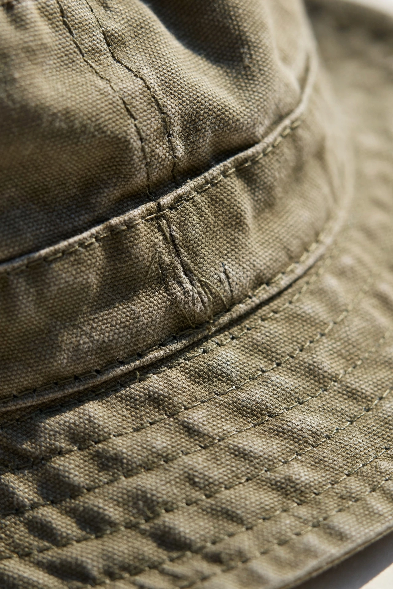 Close-up detail of bucket hat fabric showing stitching and soft brim texture