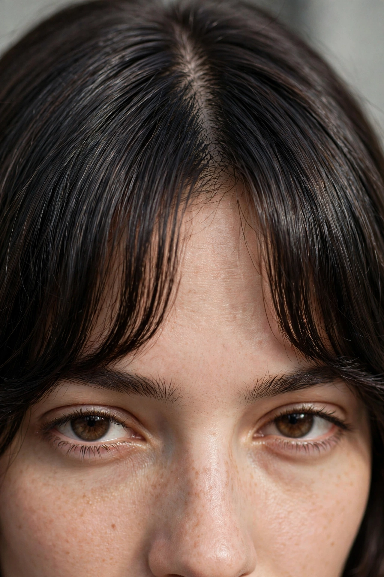 Close-up of a centre part showing how curtain bangs are cut shorter in the middle and longer at the sides