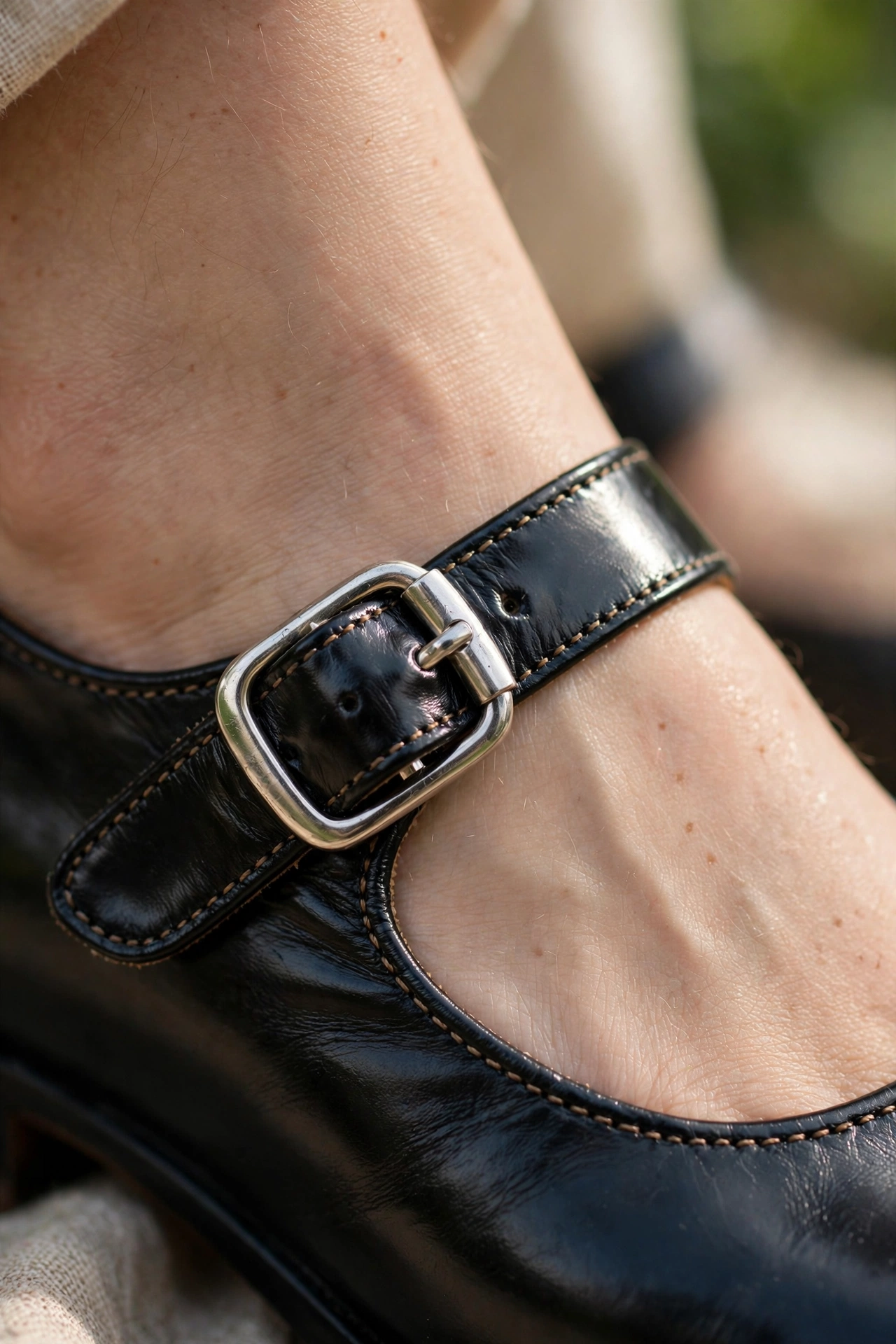 Close-up detail of a black Mary Jane shoe strap and silver buckle