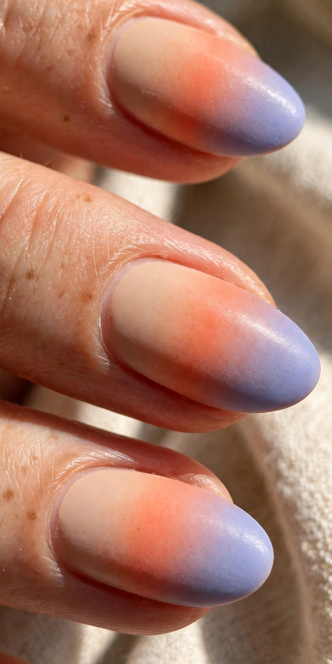 Close-up of ombre gradient nails in sunset shades showing the smooth colour blend